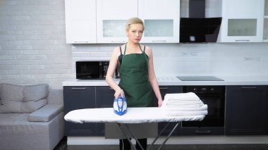 beautiful woman in a leather corset and apron irons