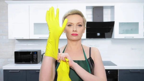 Humor. mujer en corsé de cuero, se pone guantes de goma. limpieza — Foto de Stock