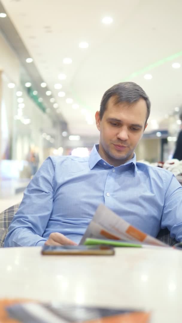 Tiro vertical de um homem cansado no menu olhando café — Vídeo de Stock