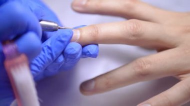 Erkek donanım manikürü. Yakından, lastik eldivenli bir manikürcünün elleri..