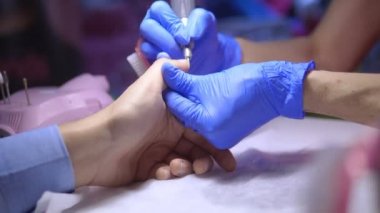 Erkek donanım manikürü. Yakından, lastik eldivenli bir manikürcünün elleri..