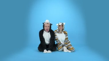 Kedi ve köpek. Bir kadın ve bir adam kigurumi kedi ve köpek. mavi arkaplan