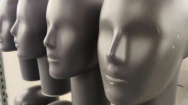 Kafası, düzgün bir sıra halinde dizilmiş gri mankenler. Geometri, minimalizm.