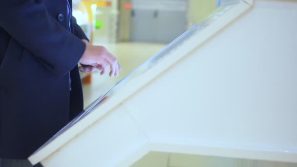 남자는 슈퍼마켓에 있는 정보 데스크에서 터치스크린을 사용 한다 — 비디오