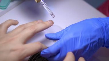 Erkekler için manikür. Manikürcü tırnaklarını yağlıyor.