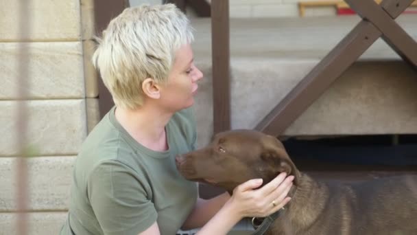 Stijlvolle mooie vrouw knuffelen hond in de tuin op een heldere zonnige dag — Stockvideo