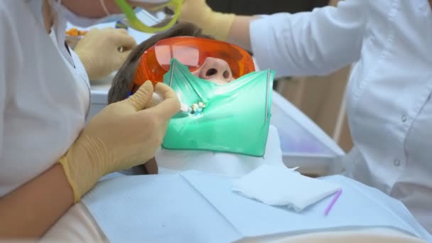 Closeup. dentist treats tooth male patient. using cofferdam — Stock Video