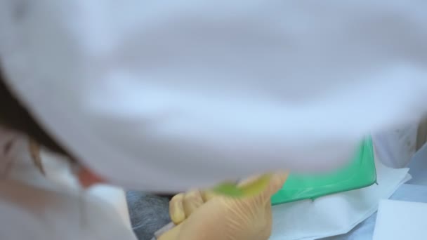 Primer plano. doctor dentista trata dientes paciente hombre usando cofferdam — Vídeos de Stock