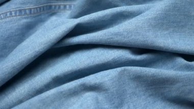 Kumaş arka plan. Açık mavi kot pantolon katları. Boşluğu kopyala