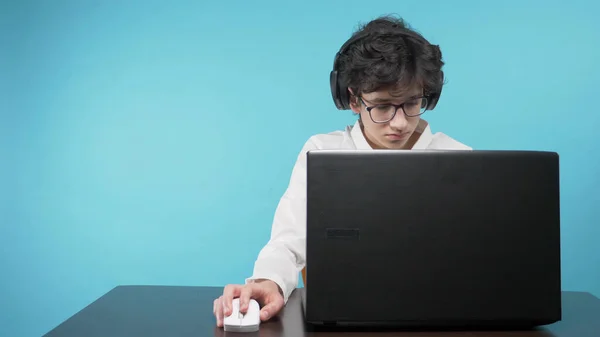 Подросток пользуется ноутбуком. голубой фон. концепция онлайн-образования — стоковое фото
