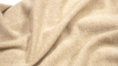 Arka plan kumaş dokusu. Bej rengi kaşmir kumaş katları. Yakın çekim