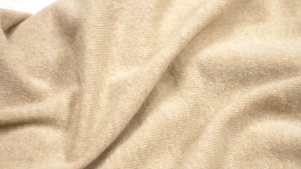 Struttura del tessuto di sfondo. pieghe di tessuto di cashmere beige. primo piano — Foto Stock