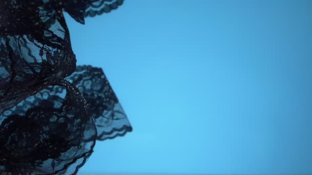 Schwarze Spitze, die sich unter Wasser auf blauem Hintergrund dreht. Kopierraum — Stockvideo