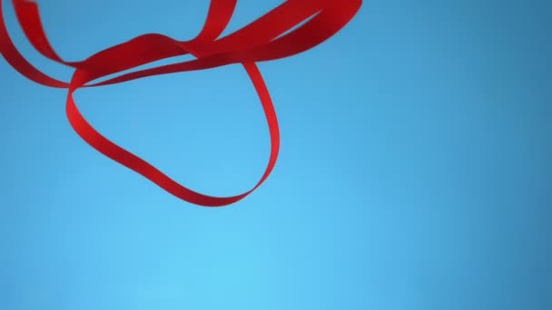 Red ribbon under water on blue background. copy space — Stock Video