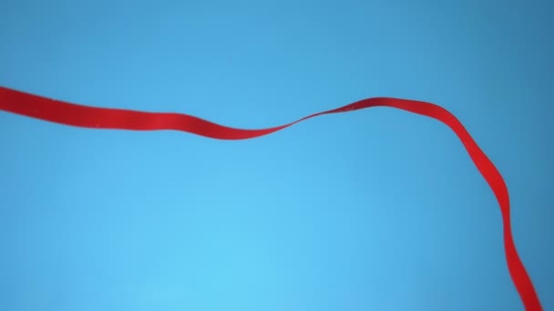 Красная лента под водой на синем фоне. копировальное пространство — стоковое видео