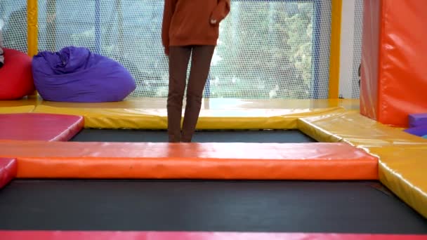 Nogi dziewczyny. Dziewczyna skacze na trampolinie w centrum trampoliny — Wideo stockowe