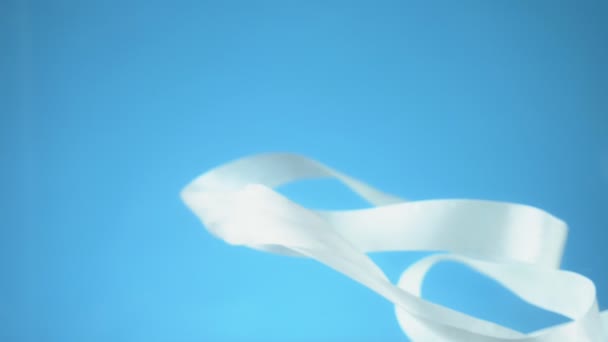 White ribbon under water on blue background. copy space — Stock Video