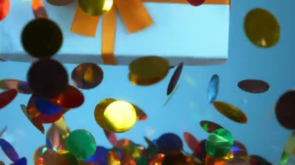 Een close-up. geschenkdoos en confetti onder water. mode ontwerp achtergrond. — Stockvideo