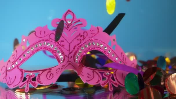 Confettis, masque de mascarade et serpentine sous l'eau sur fond bleu — Video
