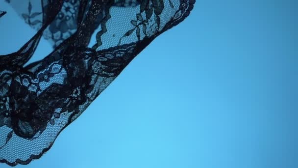 Dentelle noire filant sous l'eau sur fond bleu. espace de copie — Video