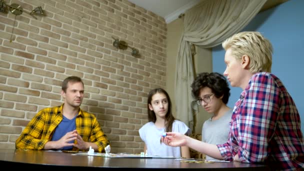 Familie Mutter, Vater, Sohn und Tochter im Teenageralter spielen zu Hause Brettspiele. — Stockvideo