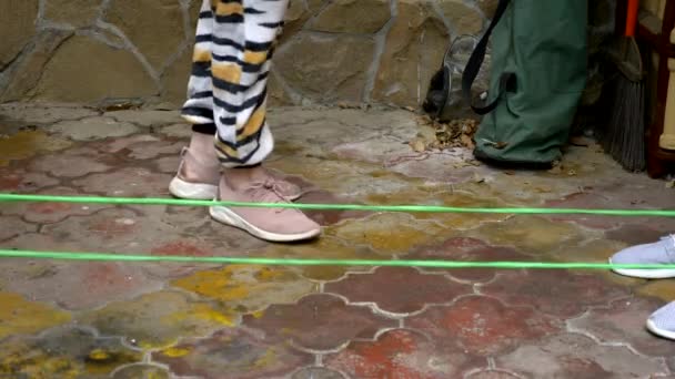 Primo piano dei piedi che saltano sopra l'elastico nel cortile posteriore. giochi attivi — Video Stock