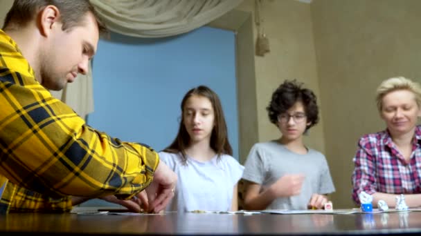 Família mãe, pai, filho adolescente e filha em casa jogando jogos de tabuleiro . — Vídeo de Stock