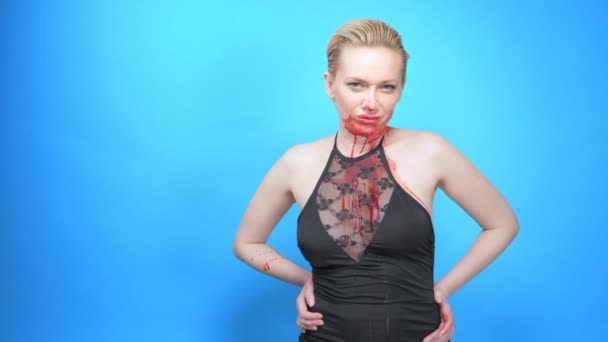 Piękna kobieta z krwawiącą twarzą na niebieskim tle. przestrzeń kopiowania — Wideo stockowe