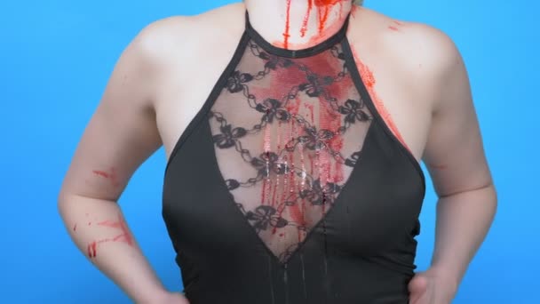 Una mujer con sangre en el pecho vestido de encaje se toca. fondo azul — Vídeo de stock