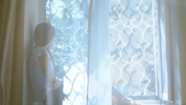 Teenager girl sitting on windowsill and looking out the window. blur. — Stock Video