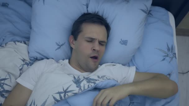 Vue de dessus. gros plan. jeune homme au lit souffrant d'insomnie — Video