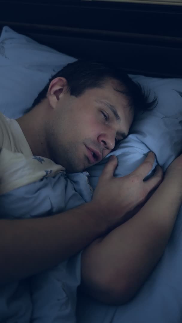 Vue de dessus. gros plan. jeune homme au lit souffrant d'insomnie. verticalement — Video