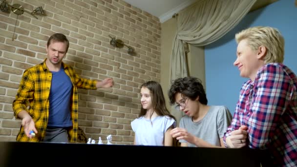 Familia mamá, papá, hijo adolescente e hija en casa jugando juegos de mesa . — Vídeos de Stock