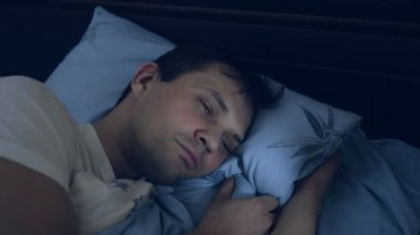 Yakın plan. Uykusuzluk çeken, gözleri açık genç bir adam..