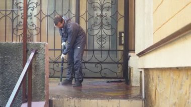 Adam dışarıdaki evi yüksek basınçlı çamaşır makinesiyle idare ediyor.