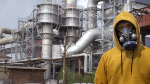 Man i respirator mot bakgrund av fabrik skorstenar — Stockvideo