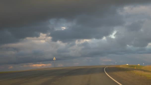 autoroute vide dans un champ. l'horizon et les nuages orageux