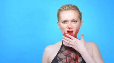 Mavi arka planda kanayan bir yüzü olan güzel bir kadın. Boşluğu kopyala