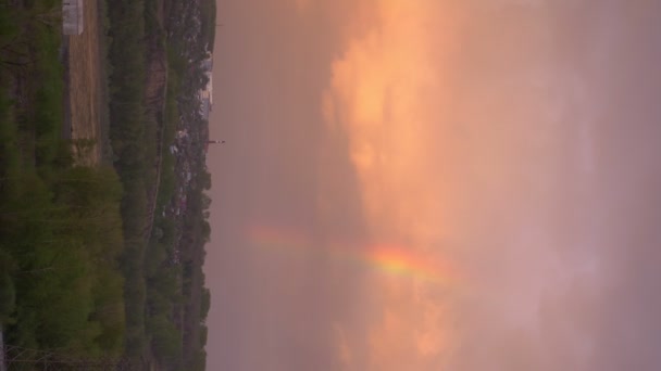 Vertikalt. regnbåge över floden under solnedgången. utsikten från bergen — Stockvideo