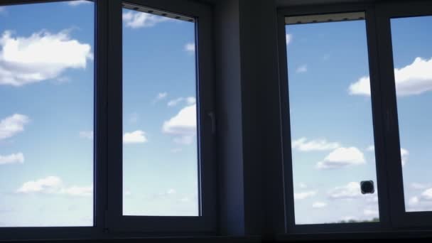 La vista desde la ventana del apartamento en el cielo azul con nubes blancas — Vídeos de Stock