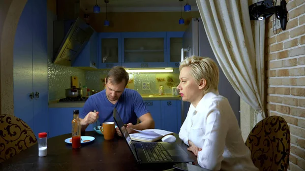 Une femme en short et chemisier travaillant à distance de la maison dans la cuisine — Photo