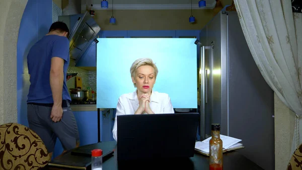 Une femme en short et chemisier travaillant à distance de la maison dans la cuisine — Photo