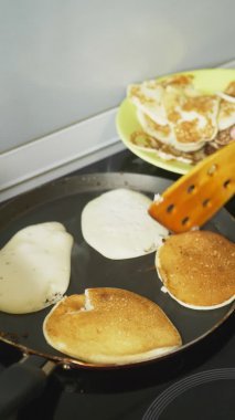 Dikey olarak. Yakın çekim, birisi tencerede krep pişiriyor.