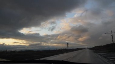 Tarlada boş bir otoyol. Ufuk ve gök gürlemesi bulutlarına,