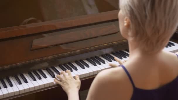 エレガントな壊れやすい女性は自宅のリビングルームでピアノを演奏し — ストック動画