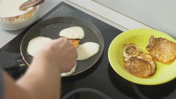 De cerca, alguien está cocinando panqueques en una sartén en una estufa táctil — Vídeos de Stock