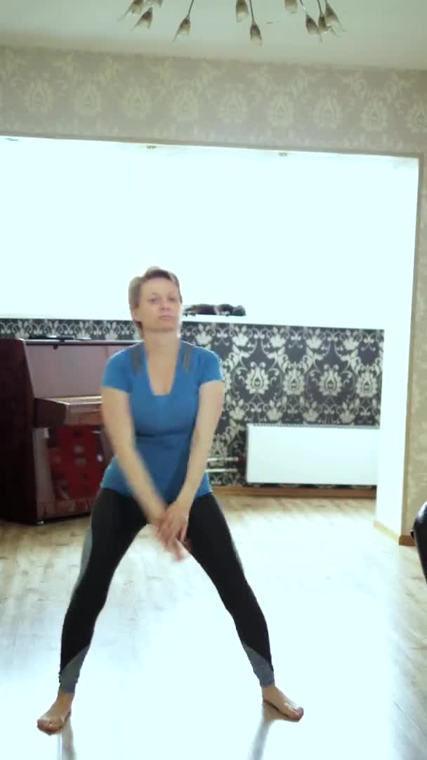 Verticalement. femme d'âge moyen faisant de la forme physique à la maison dans le salon — Video