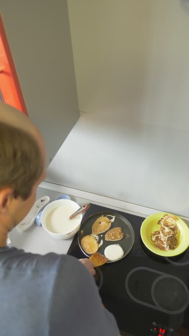 En skallig man lagar dessert hemma. Vispa vispägg med mjöl — Stockvideo