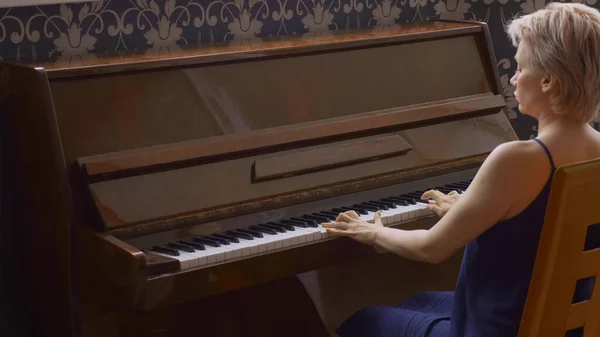 Elegante donna fragile suona il pianoforte a casa in salotto — Foto Stock