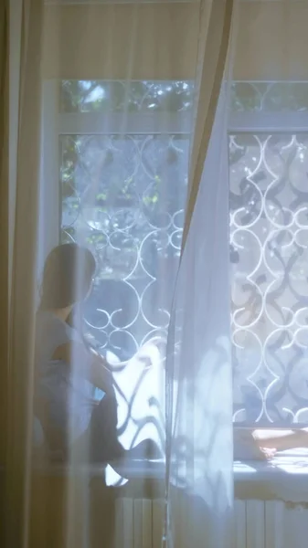 Verticaal. tiener meisje zit op vensterbank en kijkt uit het raam. vervaging — Stockfoto